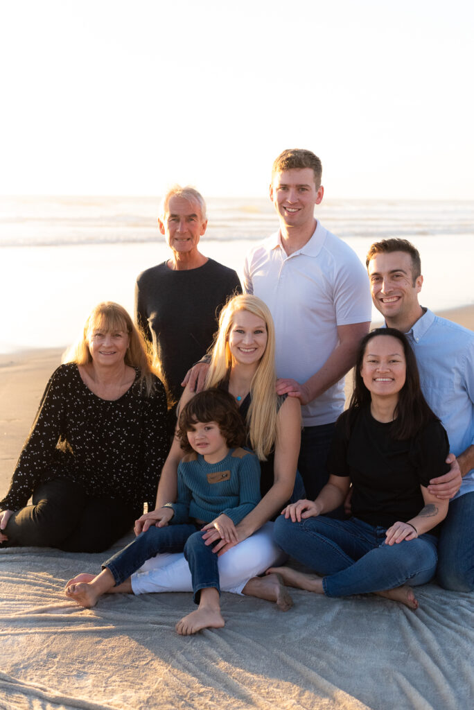 Extended family sitting on blanket at the beach during a family photo session