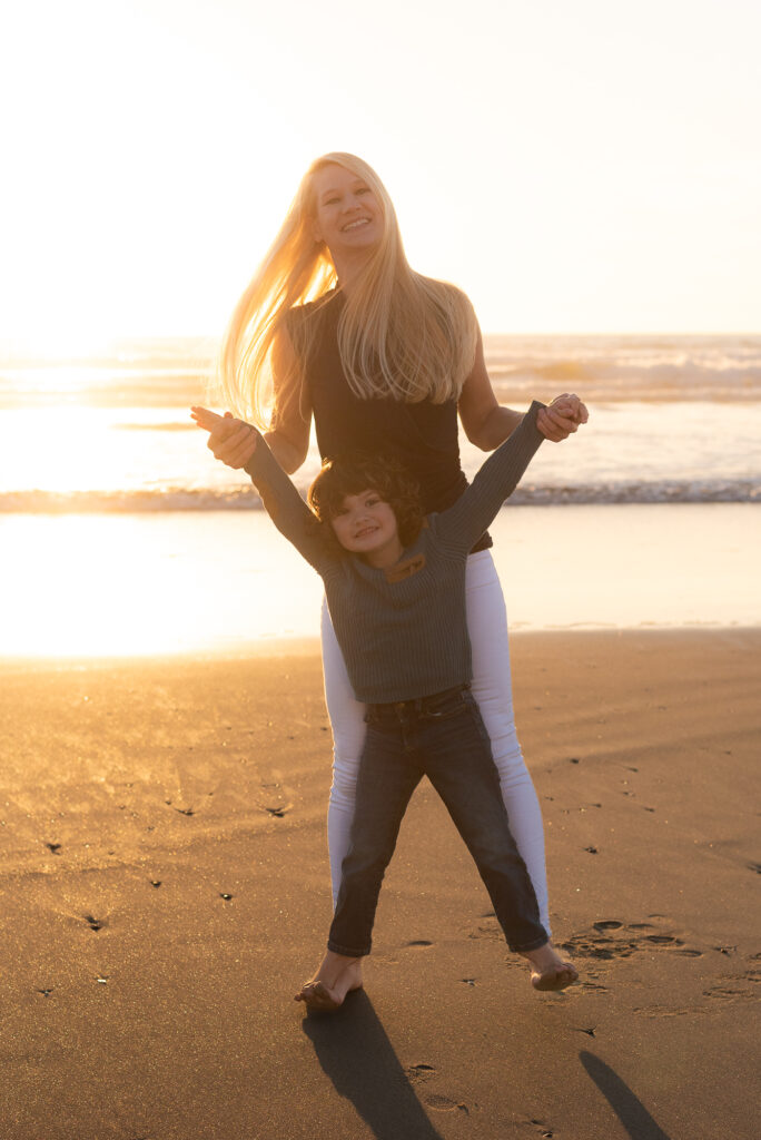Golden hour photo of mom playing with her son on the beach in Oceanside, CA