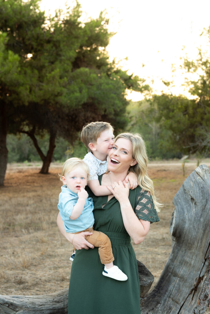 Mom holding her two young sons laughing