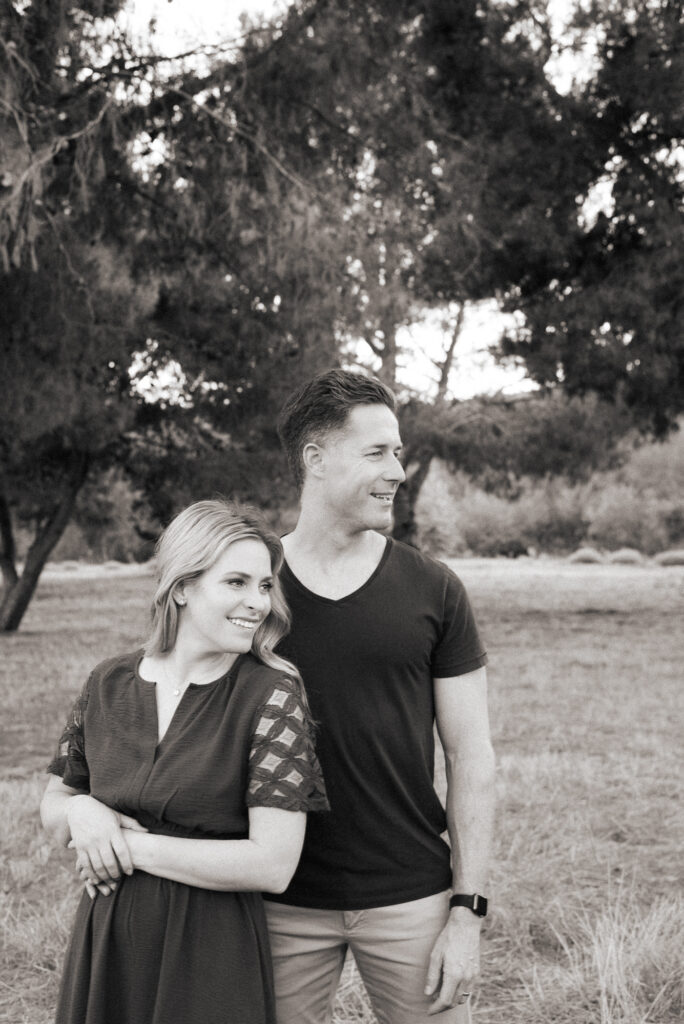 Black and white image of husband and wife looking and smiling at their kids off camera