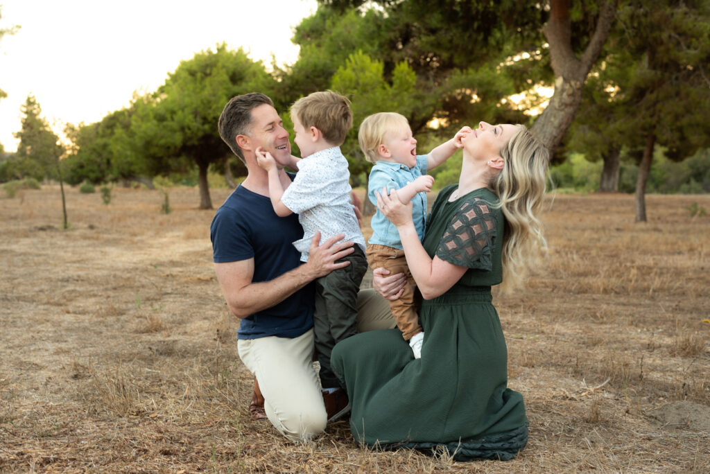 A family of four play with each each other during a golden hour photography session