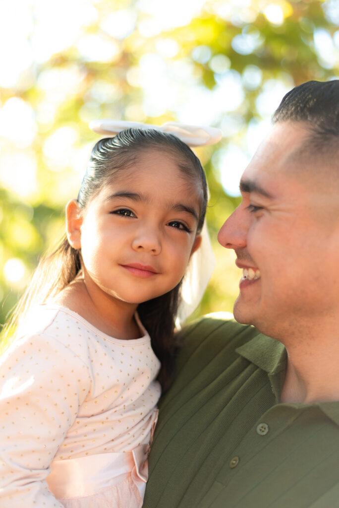 A dad holds his young daughter during a family session in Fallbrook, CA