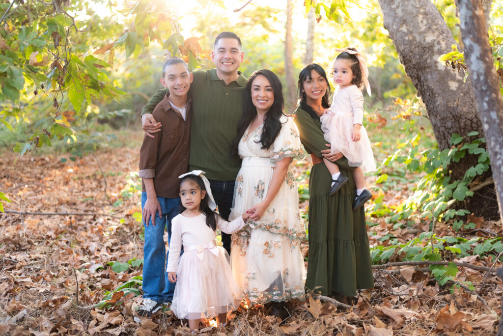 Family of four pose in a sunlit grove in Fallbrook, CA