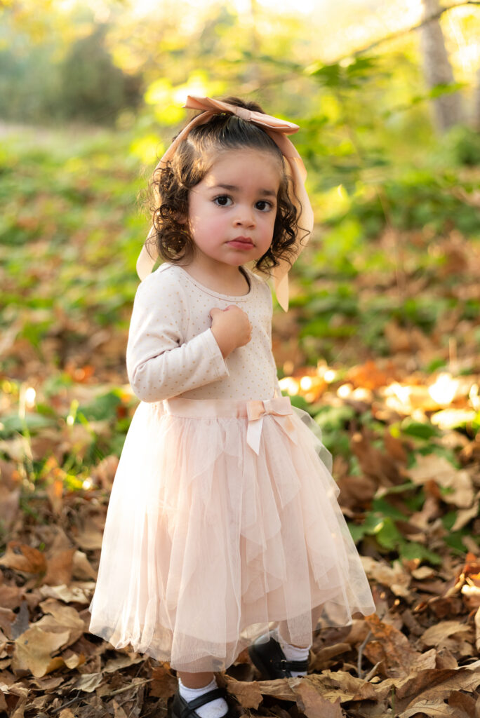 A toddler girl looks at the camera during a family session in Fallbrook, CA