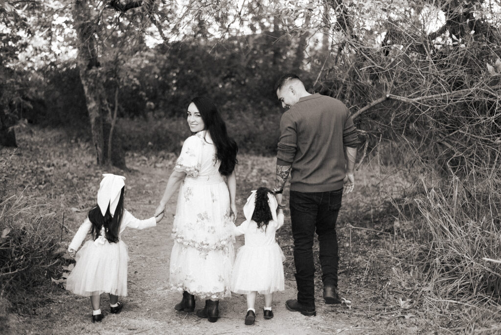 A family walks with their little girls as the mom looks back at the camera in Fallbrook, CA