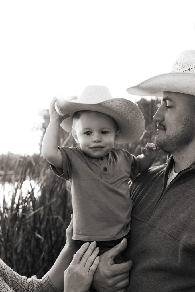 Toddler tries on a cowboy hat during family photography session in Lodi, CA