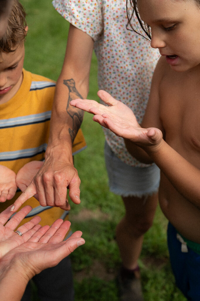 Kids look at each others hands during a documentary family photography session